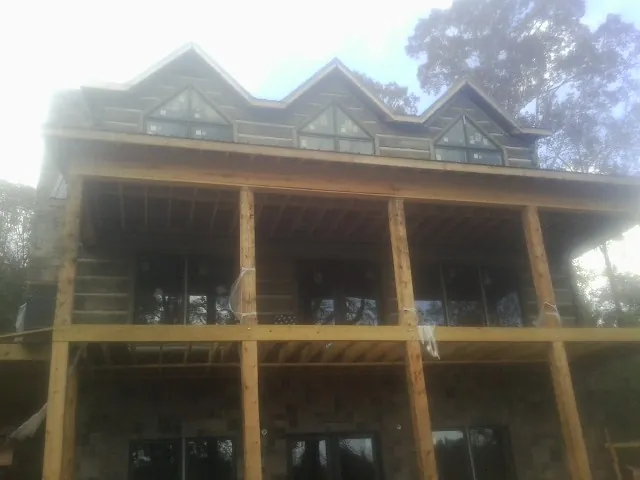 Dormers and porch framing on a large log home under construction — Roof Coating work by our crew in Vaughan