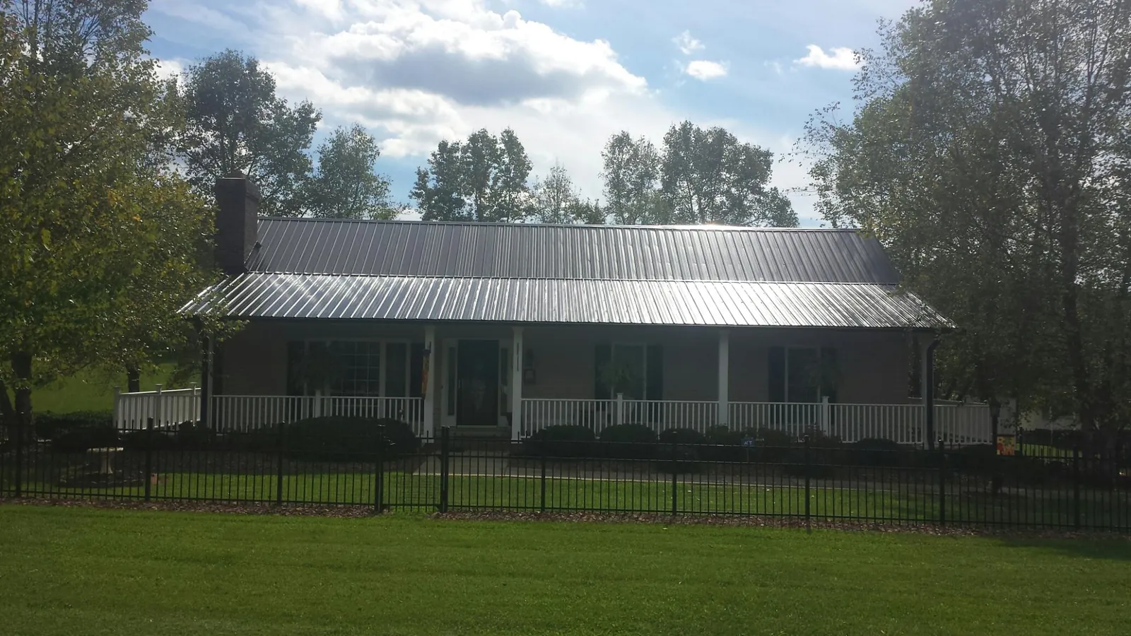Gray metal roof on a brick ranch with a full width front porch — Gutter Guard Installation work by our crew in Vaughan
