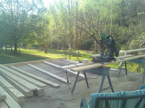 Miter saw and framing lumber on a deck under construction in Vaughan